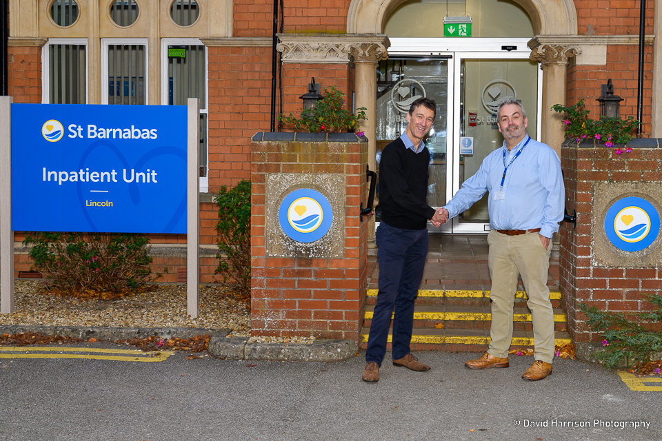 Two people shaking hands outside