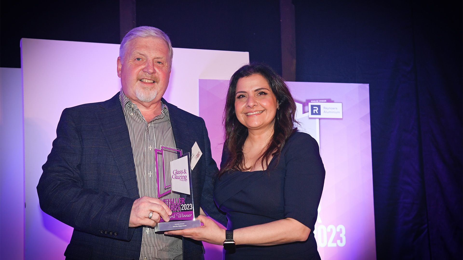 A man and woman holding a trophy.